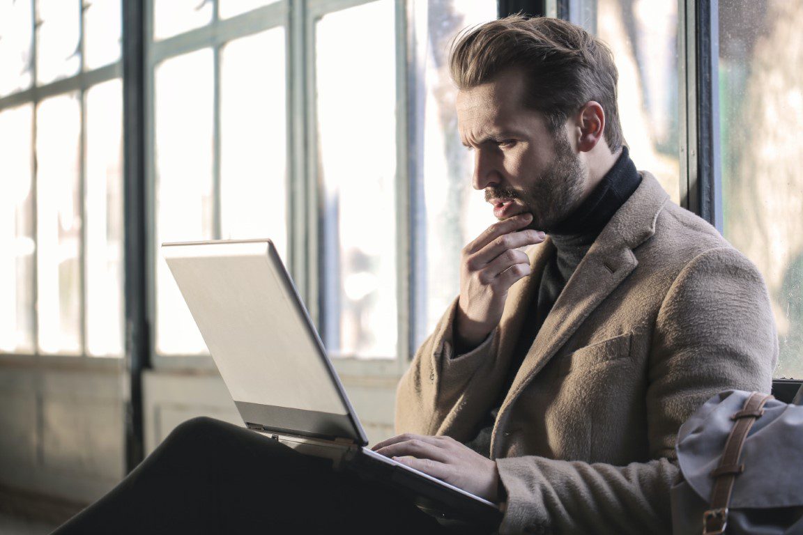Image of a confused man with a laptop